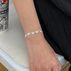 Detail view of S925 sterling silver heart zircon bracelet worn on a woman's wrist