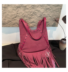 Detail of bohemian purple fringe bag with sun embossing and metallic stud accents