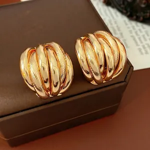 Golden multi-layer woven hoop earrings with polished and brushed metallic texture