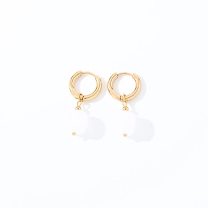 Detail of gold geometric hoop earrings with polished finish and translucent square stones