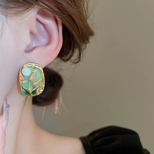 Detailed close-up of retro French floral earrings with pink tulips and gold edges