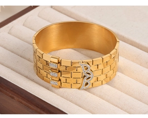 Detail of 18K gold plated wide cuff bracelet featuring brick texture and crystal accents