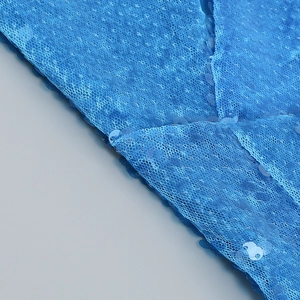 Macro shot of high-density blue sequins and mesh fabric for a slim-fit evening dress