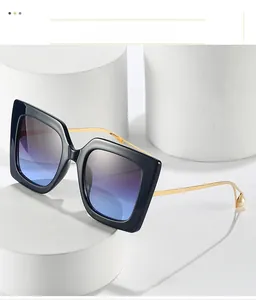 Detail of square oversized sunglasses with gradient lenses and gold metal pearl temples