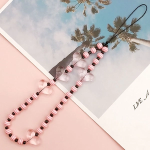 Detail of pink striped beads and transparent heart charms on a handmade phone strap