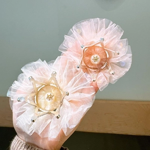 Close-up of lace crown hair clips with pearls and gold stars in pink and beige