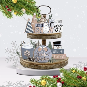 Close-up of tiered tray set with gray wooden snowmen and Christmas festive ornaments