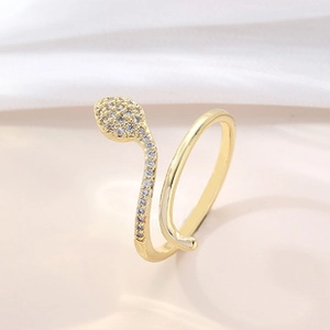Macro shot of gold snake ring with sparkling white zircon stones and polished finish