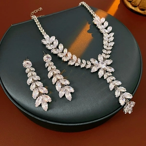 Detailed view of silver wheat ear tassel necklace and earrings set on black stand