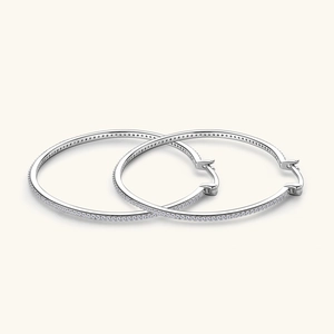 Macro detail of large silver hoop earrings featuring pavé set sparkling moissanite stones