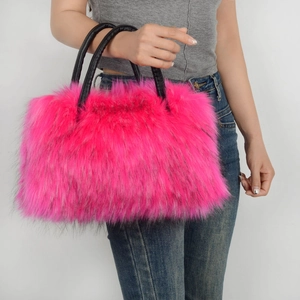 Chic pink faux fur tote bag with black handles held by model in casual outfit