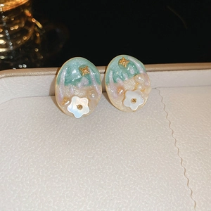 Detail of vintage French gold-plated oval stud earrings with pearls and shell flowers