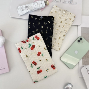 Vue détaillée de pochettes de téléphone en mousseline fleurie avec fermeture à bouton