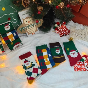 Détail de quatre paires de chaussettes de Noël en coton dans un coffret cadeau festif