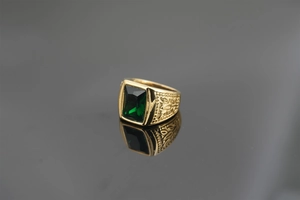 Close-up of vintage gold ring featuring a green rectangular gemstone and side carvings