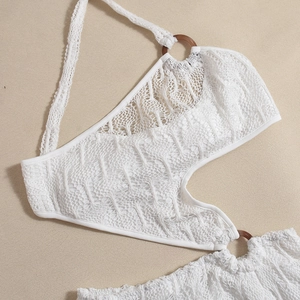 Detail of white crochet beach dress featuring sheer knit pattern and brown ring accent