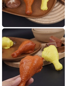 Detail of realistic PVC chicken drumstick model with skin texture on wooden tray