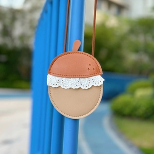 Detail of acorn shaped kids mini pouch with PU leather, lace trim and long strap