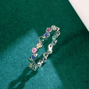 Minimalist silver ring featuring vibrant multi-colored cubic zirconia stones on green background