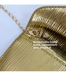 Détail de la chaîne dorée avec fermoir mousqueton sur sac à texture ondulée