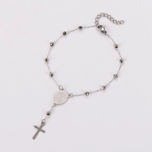 Macro view of silver religious rosary bracelet with Virgin Mary medal and cross pendant