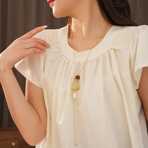 Y-shaped necklace featuring tiger eye bead and a white pearl drop on a golden chain