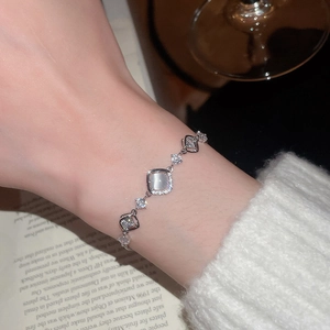 Detailed close-up of zircon flower bracelet with cat eye stone on a model wrist