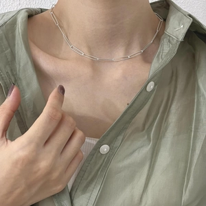 Detailed close-up of a 925 sterling silver paperclip chain necklace on a female neck