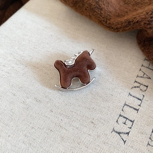 Close-up of a brown flocked rocking horse brooch with sparkling diamond saddle details