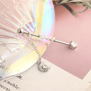 Detail of silver industrial ear piercing with moon pendant and clear gemstones