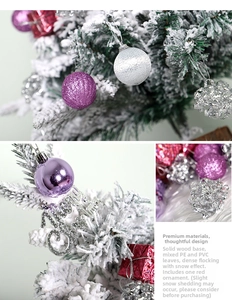 Detail of flocked Christmas tree with purple ornaments, red gifts and wooden base