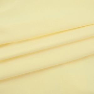 Close-up of pale yellow fabric texture showing fine weave and ruffled edge detail