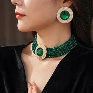 Close-up of emerald green beaded necklace and matching round earrings set on a model