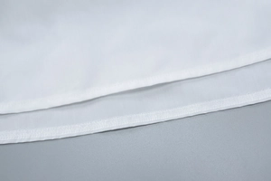 Detail des weißen Kleidsaums mit präziser Doppelnaht und hochwertiger Stofftextur