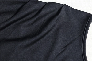 Detail of premium black pleated fabric with tight seam stitching on a modern two-piece set