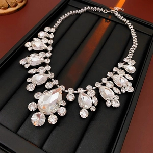 Close-up of sparkling crystal waterdrop necklace in silver on a black display stand