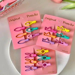 Flat lay of colorful macaron mini hair clips in bunny, crown and oval shapes
