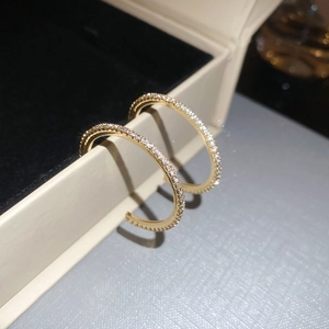Macro shot of gold-tone round hoop earrings featuring shimmering pave-set zircon crystals