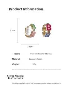 Macro view of colorful enamel letter B earrings with zircon inlays and silver needles