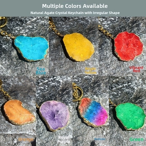Multiple colors of natural agate stone keychains with golden edges on a rocky background