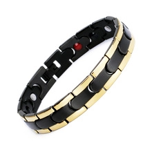 Detail showing the inner side of a black and gold magnetic bracelet with embedded magnets