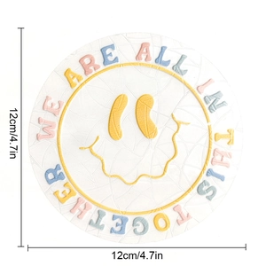 Close-up of a 12cm suncatcher coaster featuring a yellow smiley face and crackle texture
