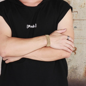 Detail of a gold hip-hop style bracelet with full pave crystals on a male model's wrist