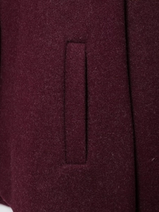 Close-up of the burgundy wool coat side pocket stitching and high-quality fabric texture