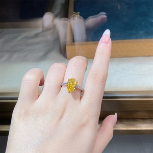 Macro detail of a pear cut yellow diamond ring with micro-pave diamonds on silver band