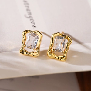 Macro view of gold-plated cross geometric earrings with rectangular cubic zirconia