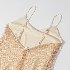 Detail of champagne sequin mesh fabric on sleeveless dress with thin straps and size tag