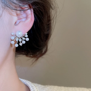 Macro detail of firework pearl stud earrings with sparkling crystals on model