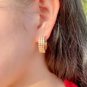 Fashionable gold-plated hoop earrings featuring multiple rows of cubic zirconia stones