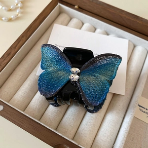 Détail d'une élégante pince à cheveux papillon bleu avec dentelle et cristaux scintillants